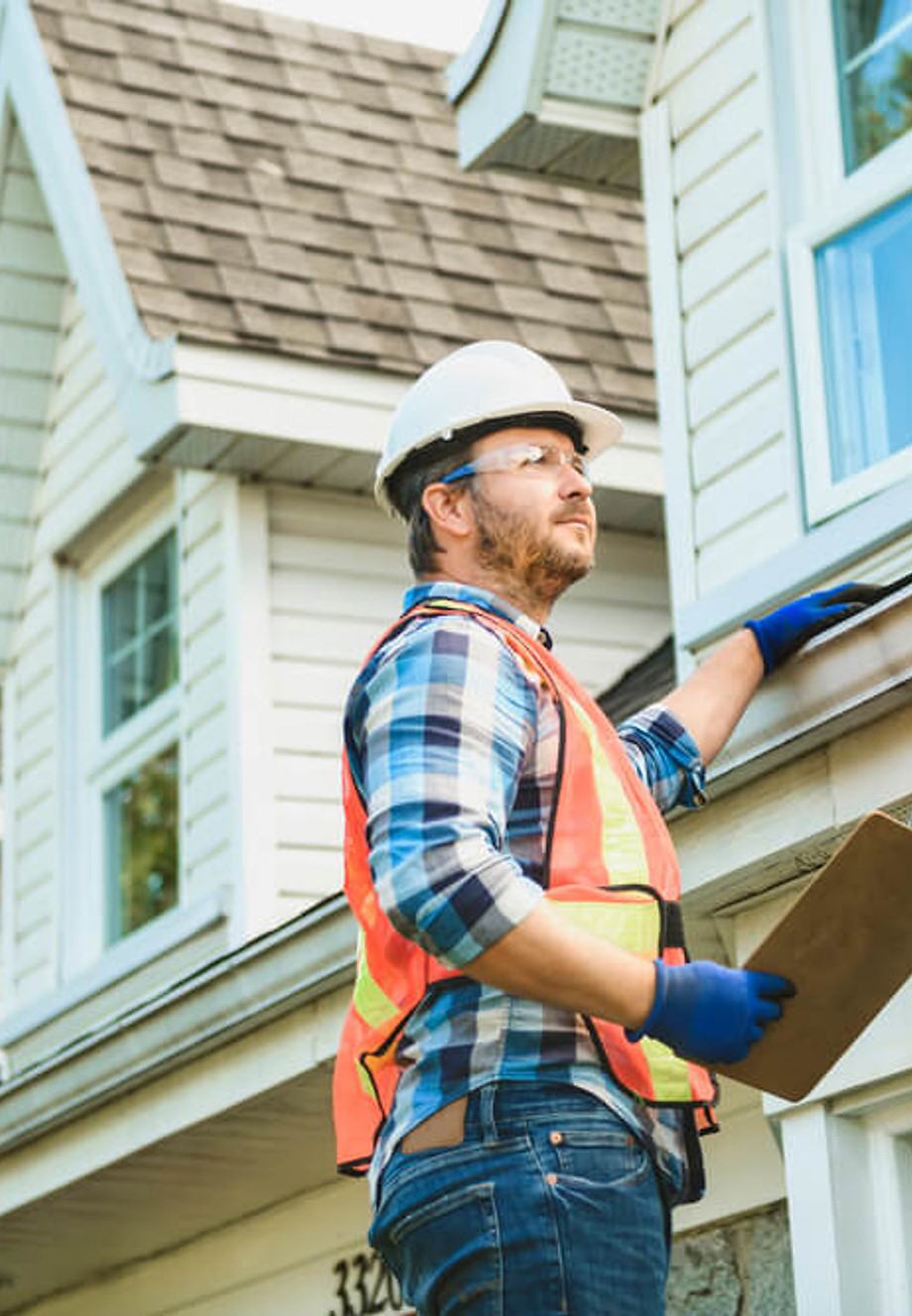 An inspector checking shingle condition on a residential roof